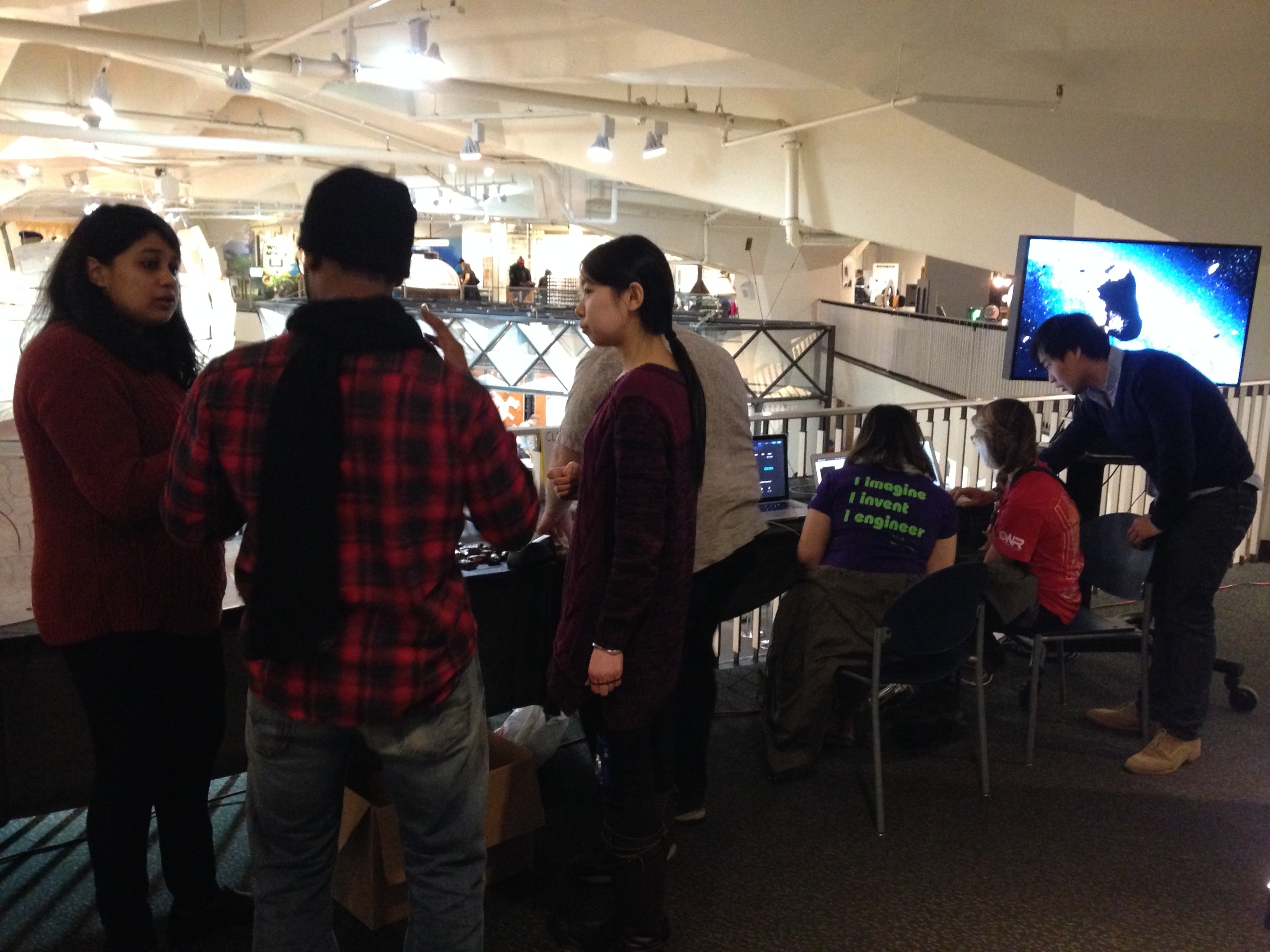 Nitya Mandyam Doddamane and Yuqian Liu talks about SDSS with some visitors, while Chang Hahn is running a demo of Skyserver. 