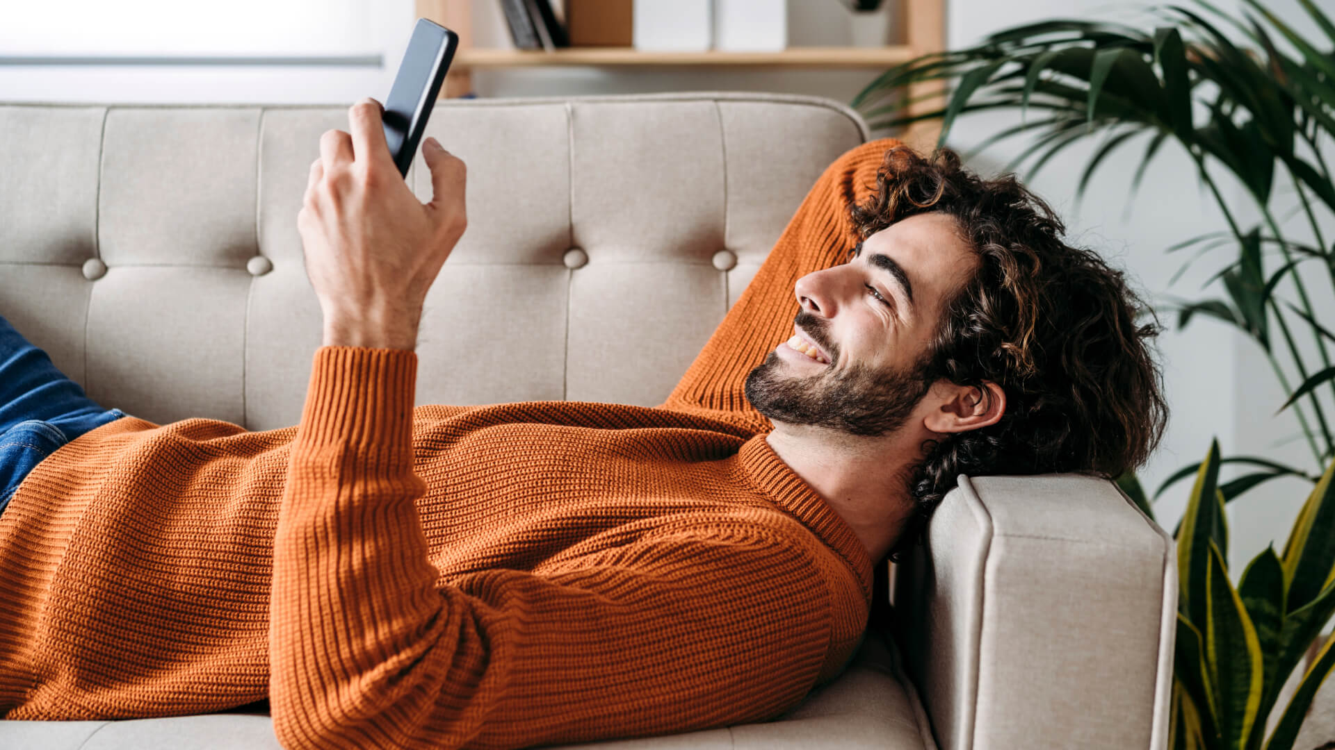 man lies on the sofa looking at smartphone thinking why choose the ii sipp