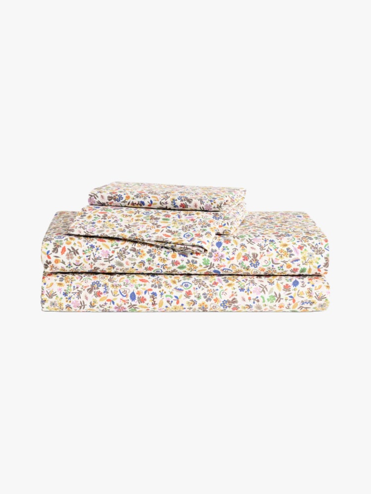 Stack of folded floral print sheets with pattern designed by Emily Isabella.