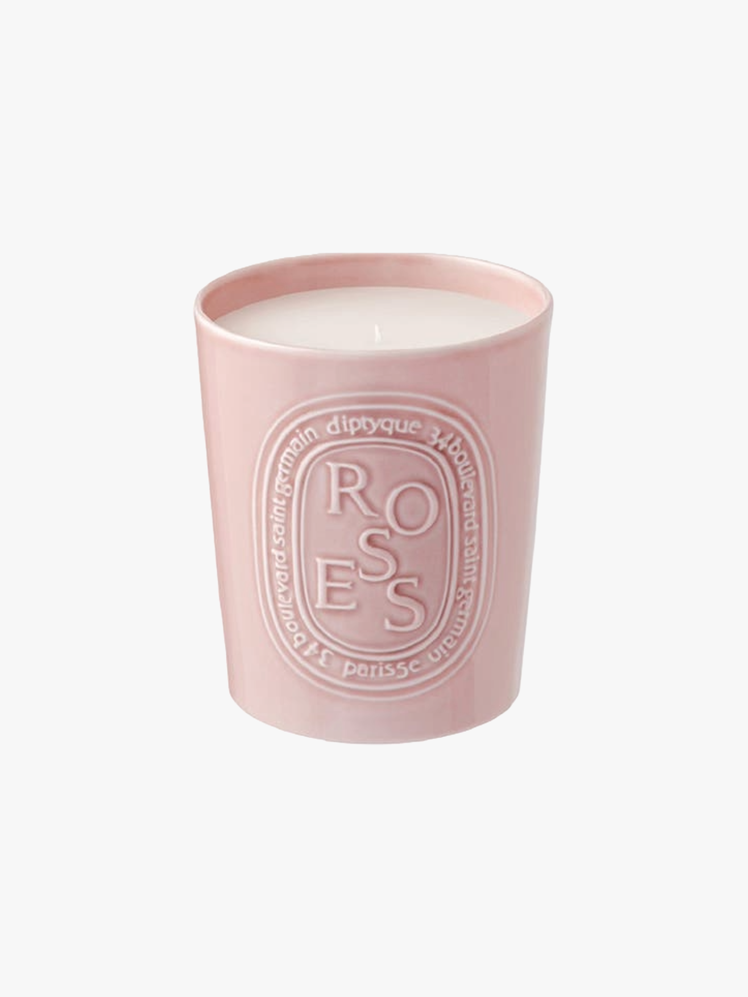 White candle in pink porcelain container.