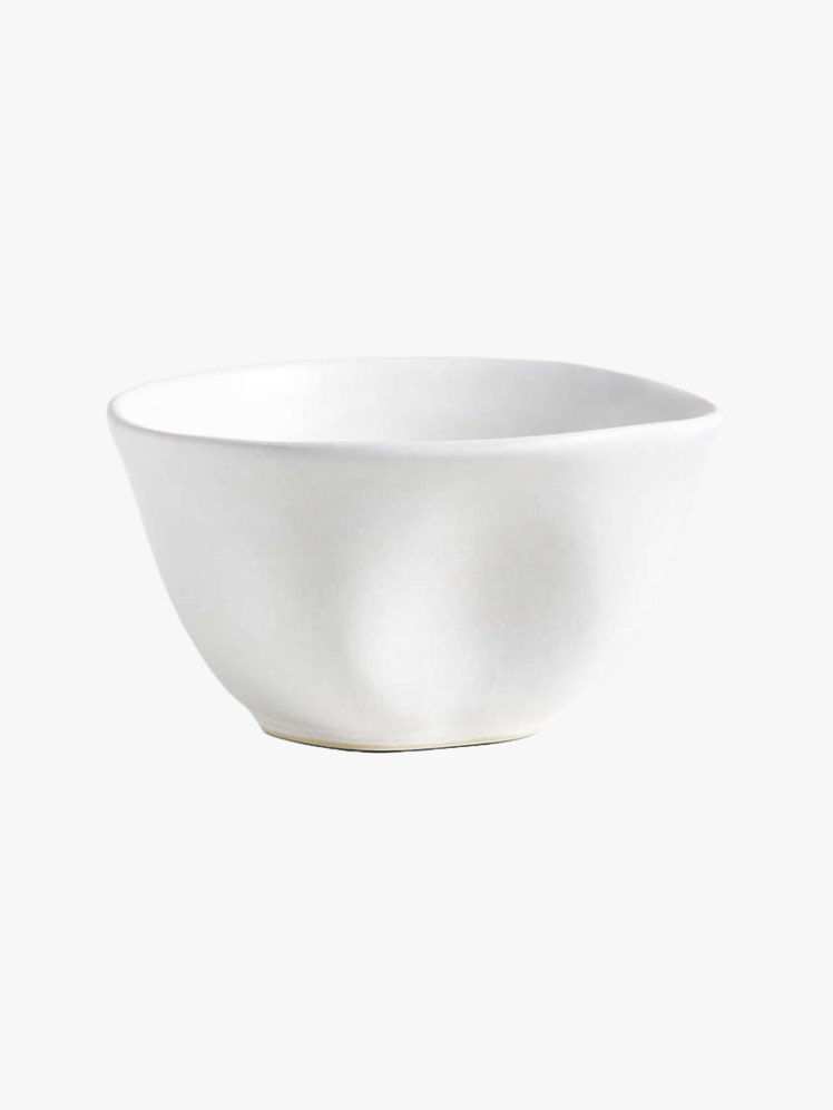 Ceramic cereal bowl with flowing curves and softly modeled indentations finished with a matte white reactive glaze.