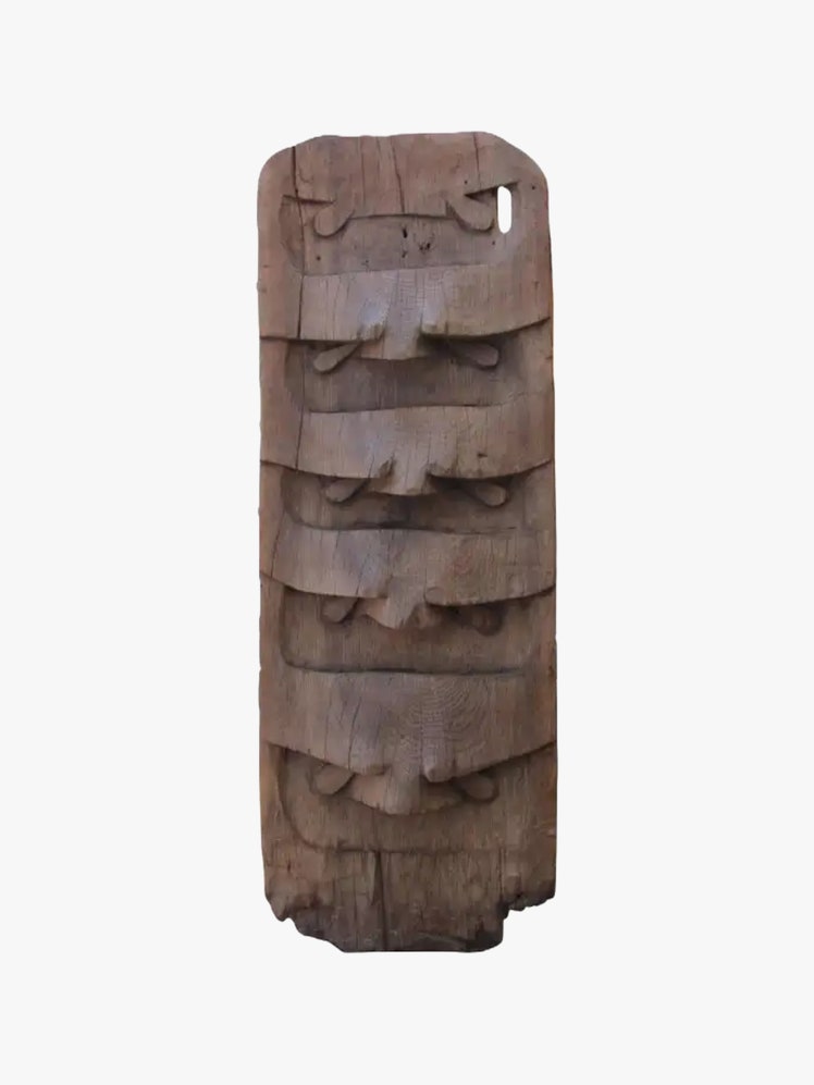 Wooden totem with eyes of owls carved into it