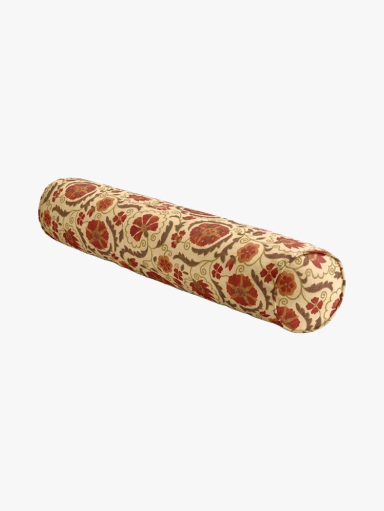 Cylindrical pillow in a red floral print fabric.