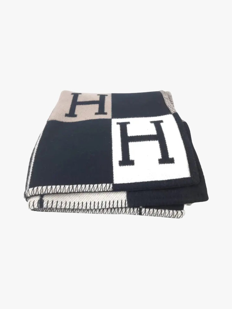 Throw blanket in jacquard woven wool and cashmere with a checkered pattern featuring an H in every other square.