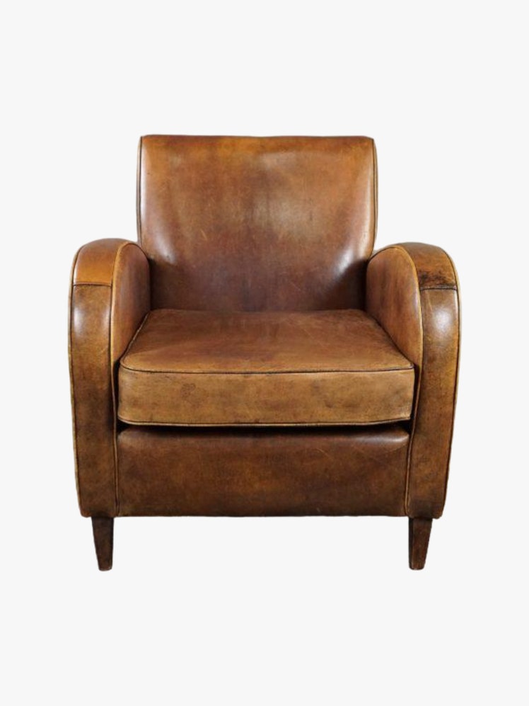 Leather armchair with a square back and rounded arms.