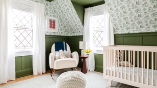 dark green wainscoting above plantthemed greenandwhite wallpaper pattern light beige crib to right gray area rug white...