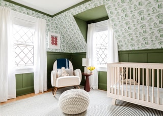 dark green wainscoting above plantthemed greenandwhite wallpaper pattern light beige crib to right gray area rug white...