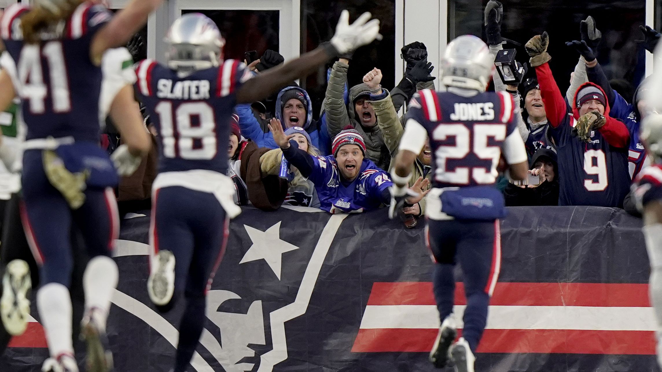 New England Patriots fans celebrate as cornerback Marcus Jones scores an 84-yard punt return in the final 30 seconds of the game to give the Pats a 10-3 win over division rivals, the New York Jets.