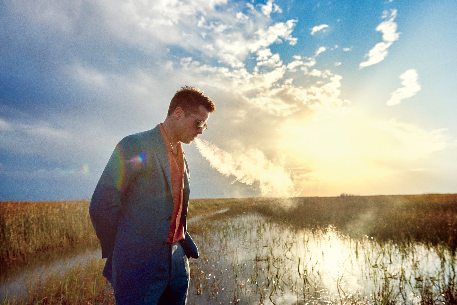 Image may contain Nature Outdoors Land Water Grass Plant Sunlight Light Flare Human Person Clothing and Apparel