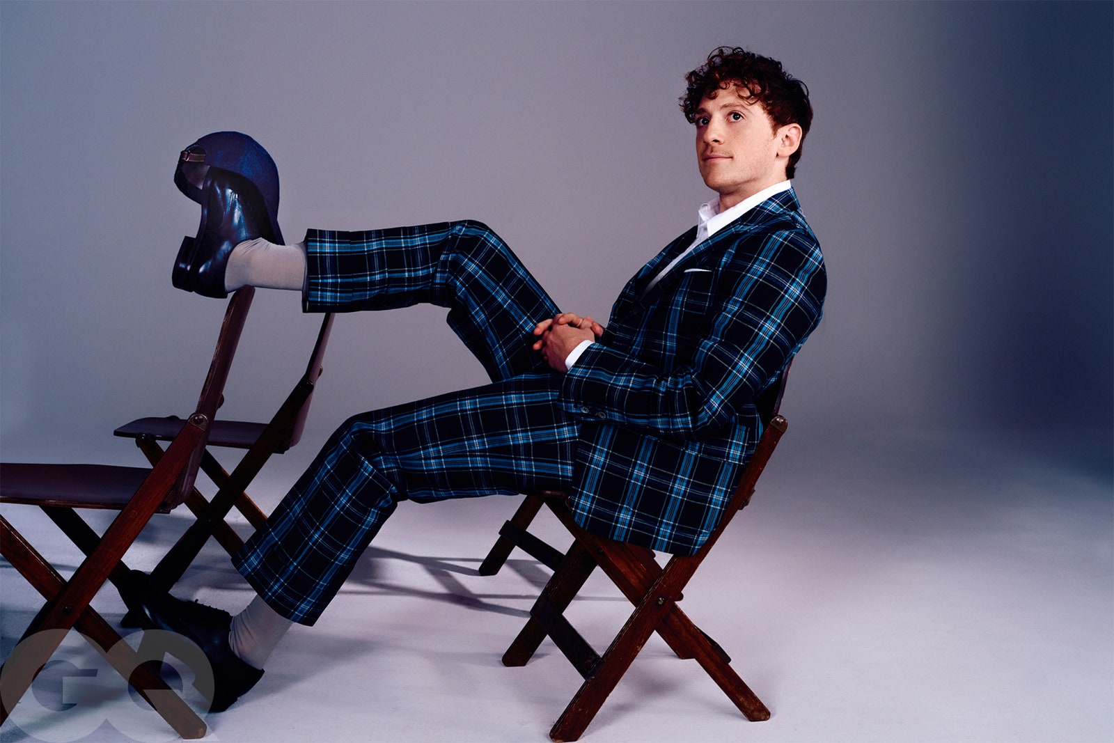 Image may contain Clothing Formal Wear Suit Person Sitting Accessories Tie Chair Furniture Adult and Pajamas