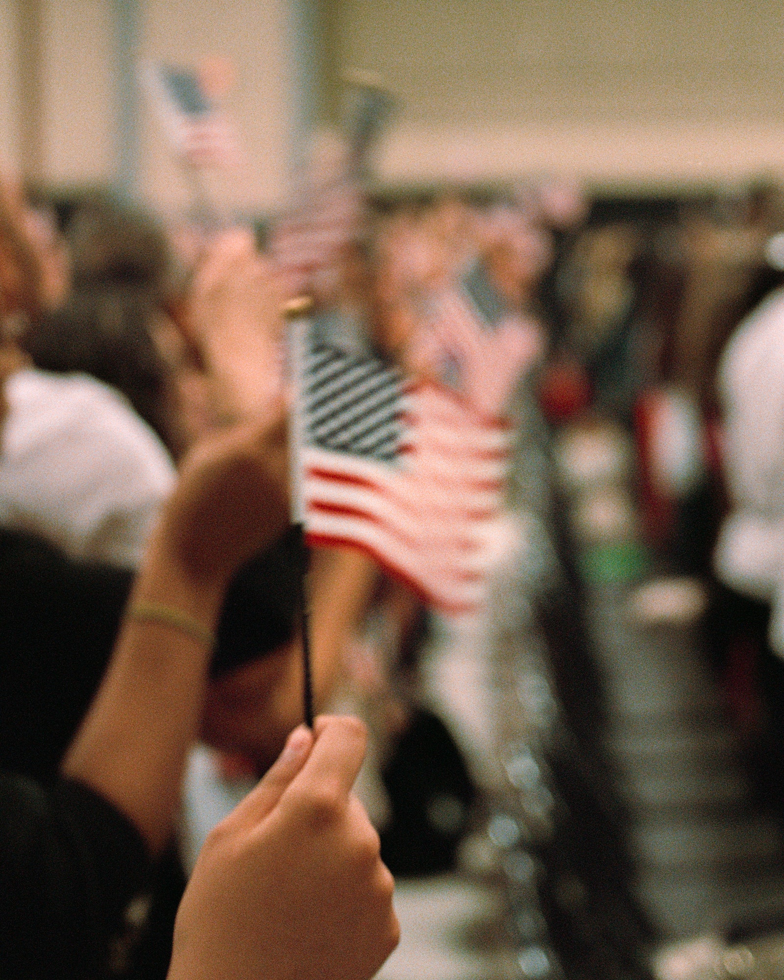 Blurry photo of people waving small American flags.