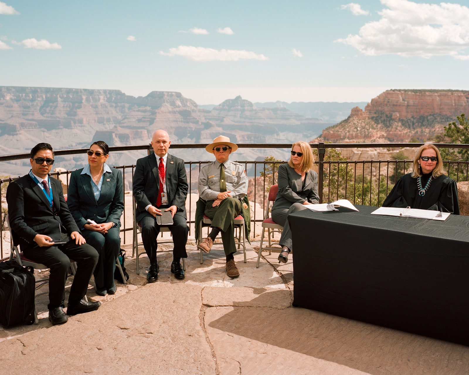 People sit in a semicircle. The Grand Canyon is behind them.