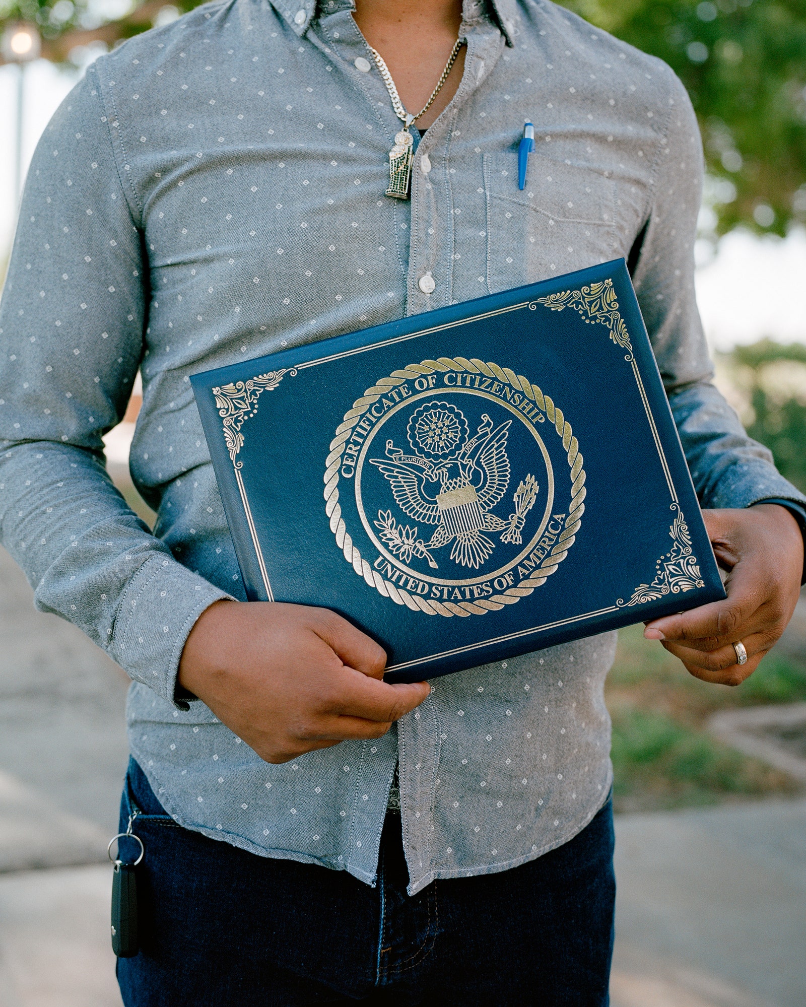 A person holding a United States Citizenship Certificate.