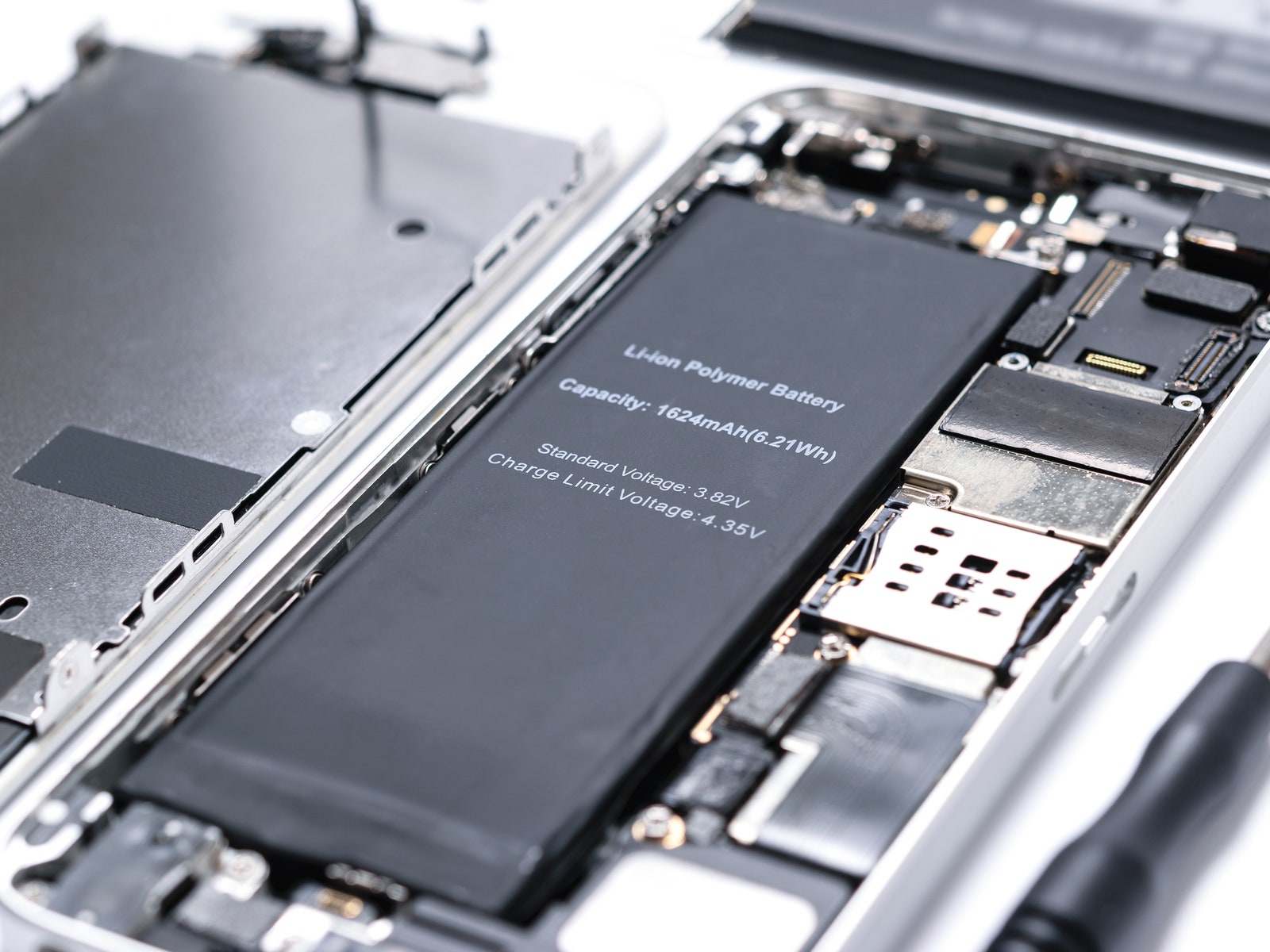 Closeup of a mobile phone taken apart with the internal components and battery exposed