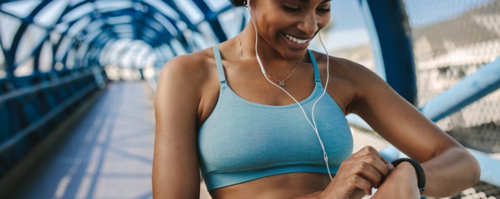 A woman checking her fitness tracker during a run