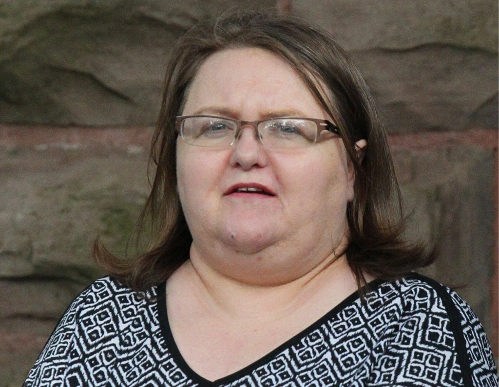  Elizabeth Wettlaufer in a white and black top is escorted by police from a courthouse
