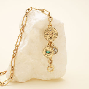 Gold Pendant Charm Necklace Staged on Stone with Cream Background