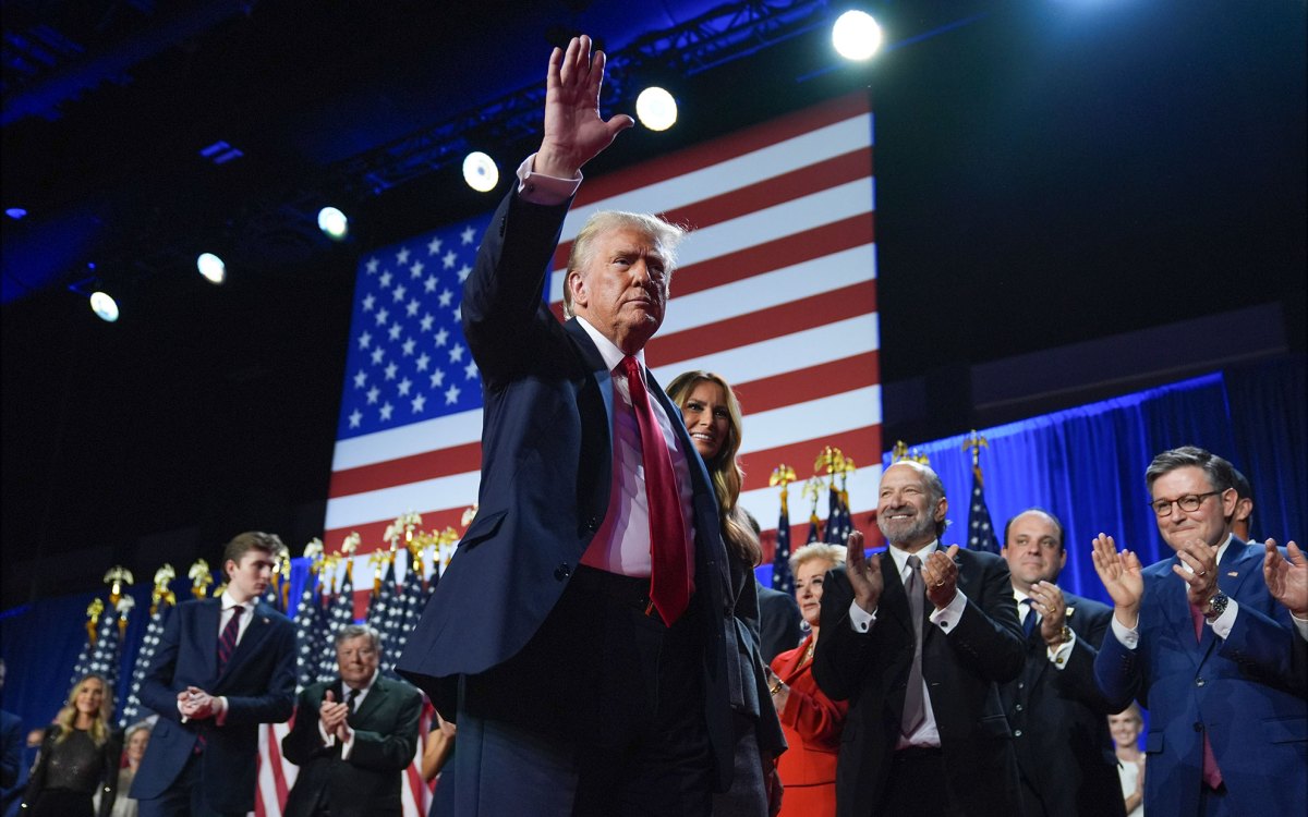 Republican presidential nominee former President Donald Trump waves as he walks with former first lady Melania Trump at an election night watch party.