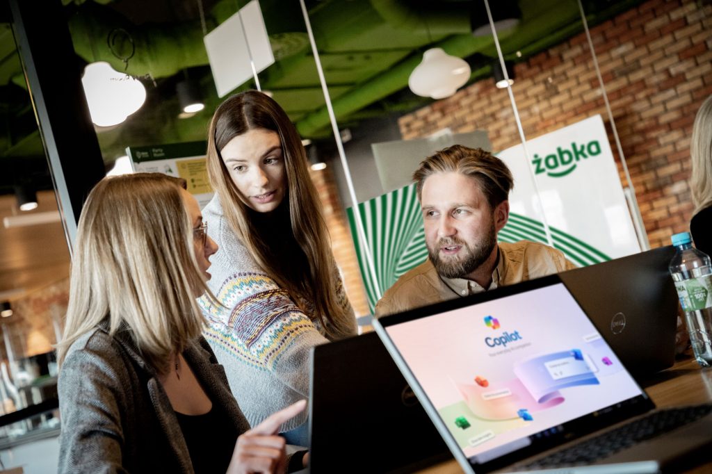 Three people working at a laptop together