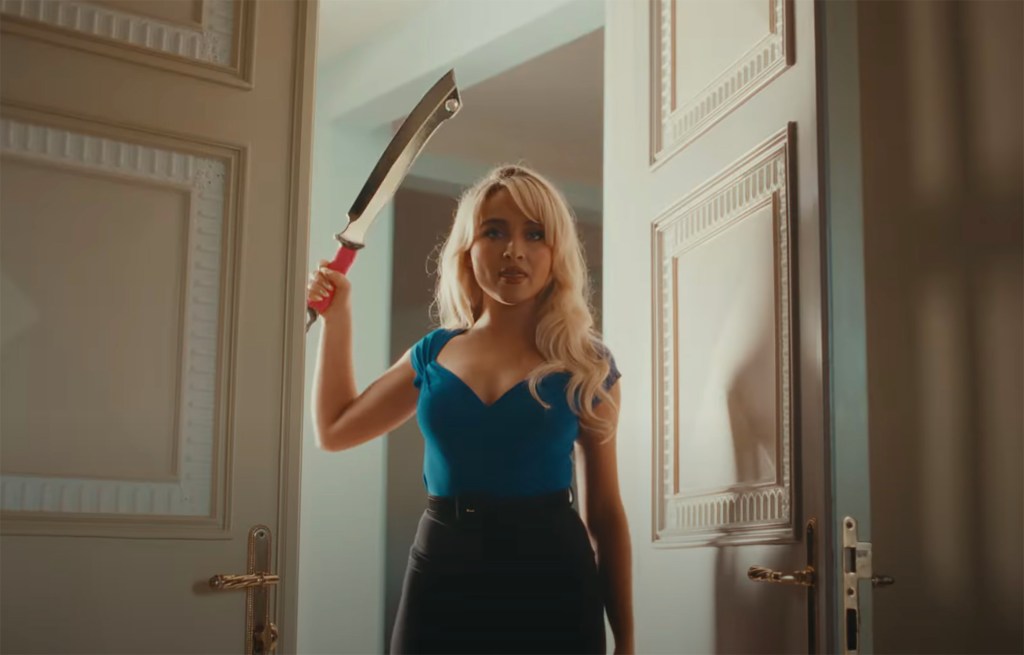 Sabrina Carpenter holds a weapon in her new "Taste" music video.