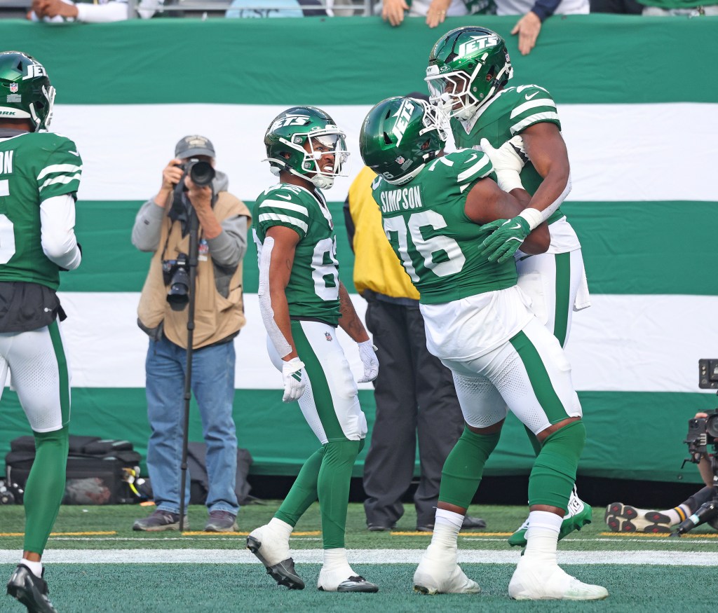 Jets lineman John Simpson (76) lifts Breece Hall (20) after Hall scores a touchdown against the Colts on Nov. 17, 2024.