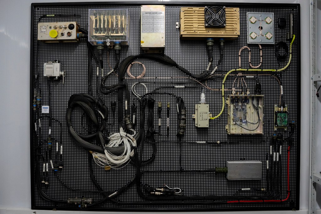 The internal mechanisms of the Shahed drone seen laid out for display in the Kyiv Scientific Research Institute of Forensic Expertise, wires and other equipment seen.