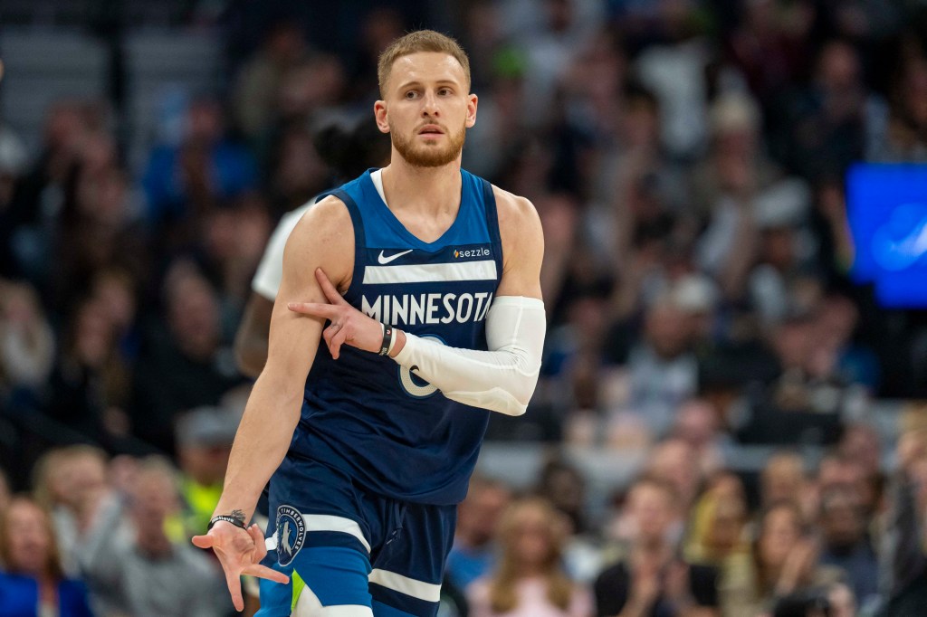 Minnesota Timberwolves guard Donte DiVincenzo celebrating after making a shot against the Miami Heat in a basketball game.