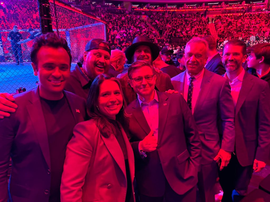 President-elect Donald Trump and his allies, including notable celebrities such as Mukhtar Sahota, Tulsi Gabbard, Jelly Roll, Robert F. Kennedy Jr., Donald Trump Jr., Kid Rock, Musashimaru Kōyō, Bill Bergey, and Bill Kenney, posing for a photo at UFC 309