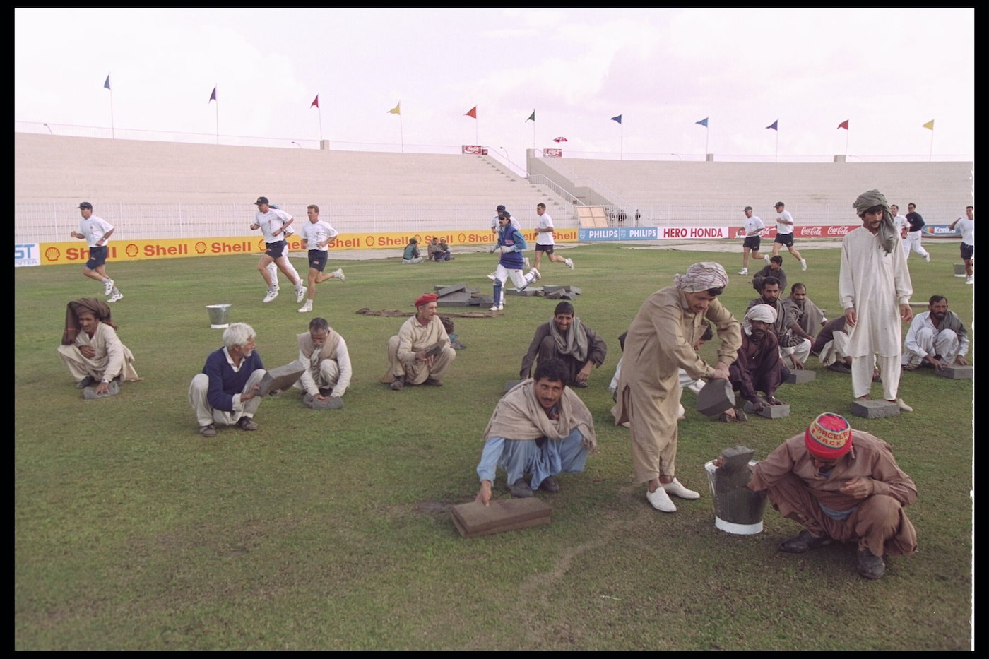 Sponge job, spare hands: ground staff mop up the outfield in Rawalpindi during the 1996 World Cup