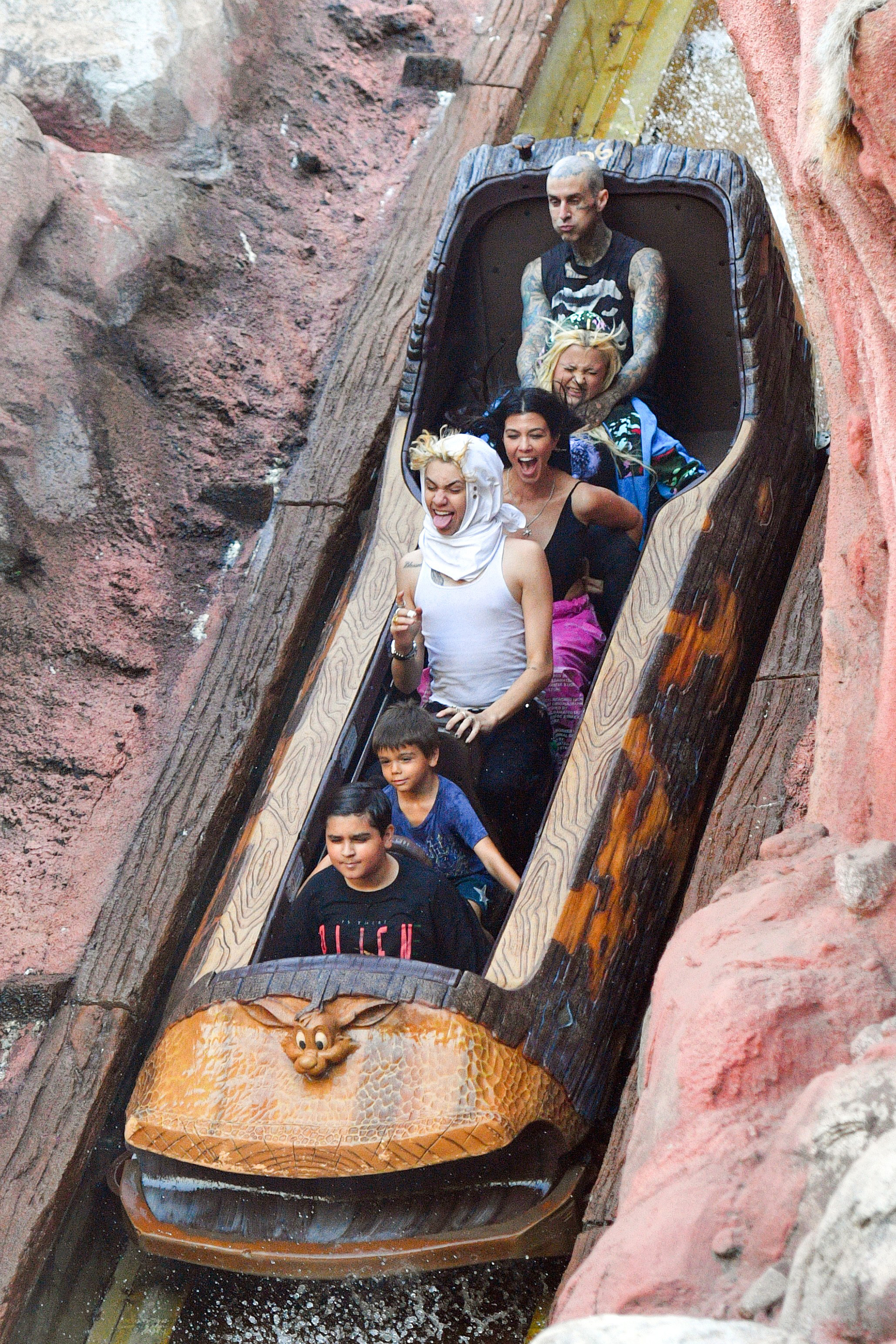 Kourtney Kardashian and Travis Barker ride the log flume at Disneyland with family.