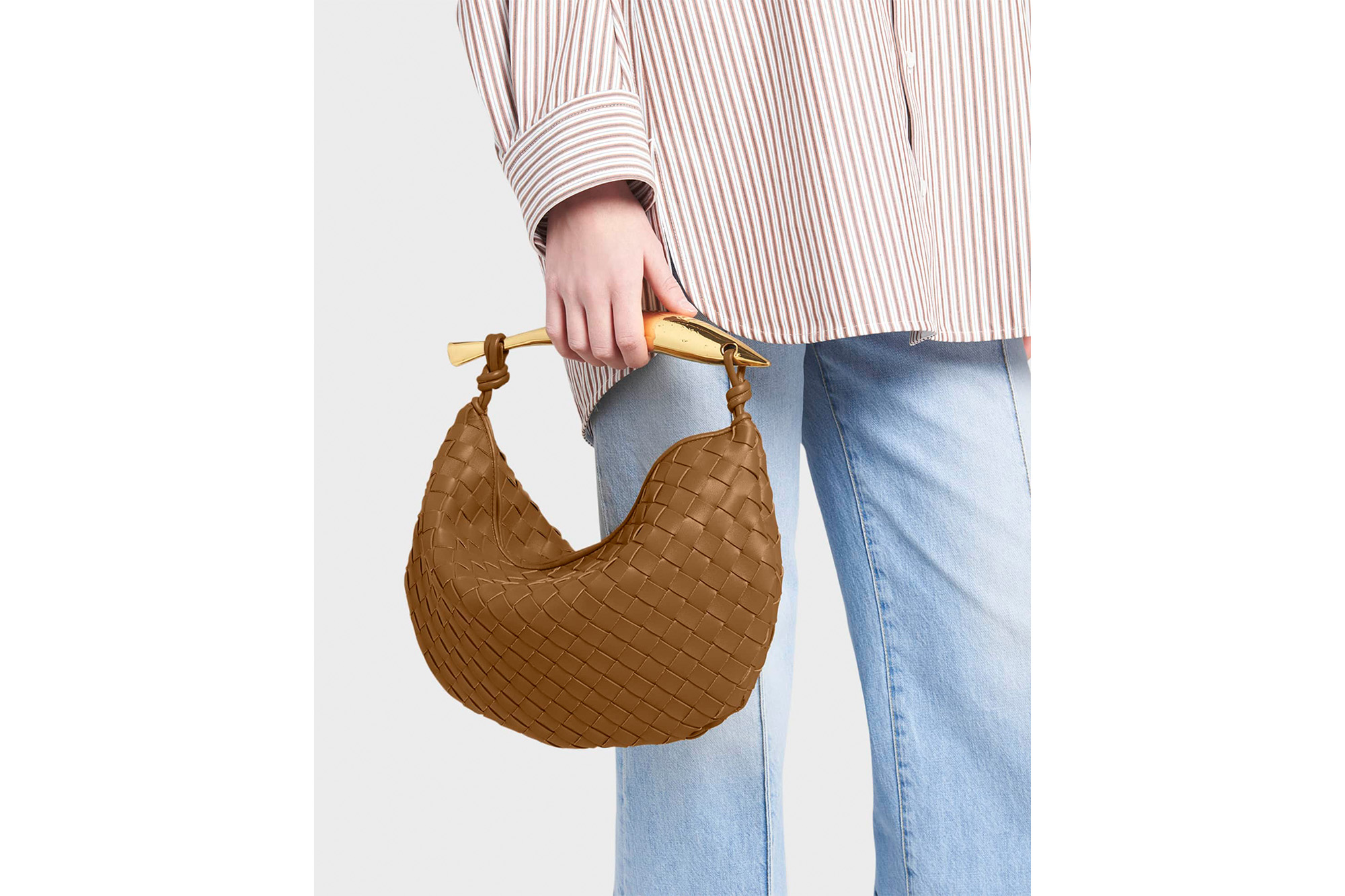 A model holding a brown Bottega Veneta sardine bag