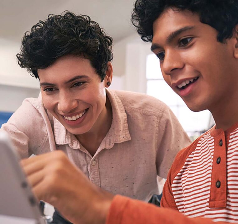 Two young men sharing a laptop computer