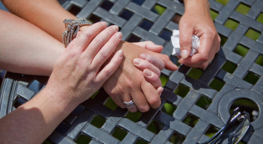 Hands holding, one has tissue in it