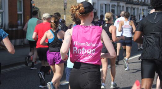 Woman running with Refuge bib on