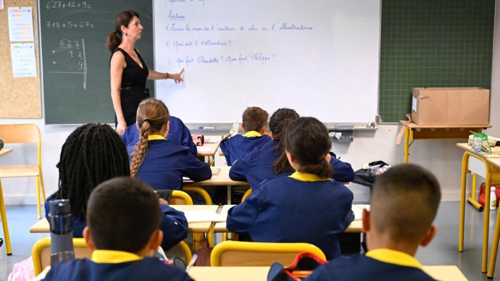 Pupils of Les Bordes primary school listen to their teacher at the start of the new school year in Metz, northeastern France, on September 2, 2024.