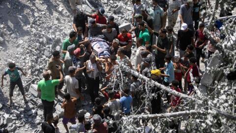 Archivo-Palestinos evacuan a supervivientes de debajo de los escombros después de que un ataque aéreo israelí destruyera varias casas en el campamento de Khan Yunis, en el sur de la Franja de Gaza, el 27 de agosto de 2024.