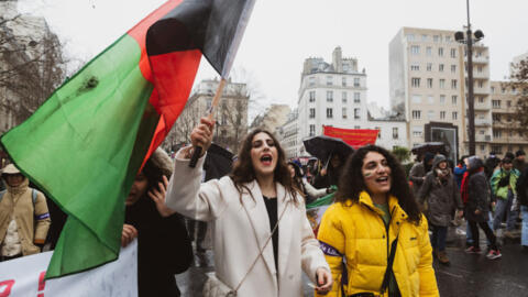 Marzieh Hamidi (C) chants slogans with the crowd, including the "women, life, freedom" holding an Afghan flag, in support of Iranian and Afghan women, Paris, 8 March, 2023.