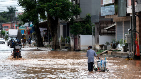 Les gens traversent les inondations suite à l'impact du typhon Yagi, à Chiang Rai, dans la province nord de la Thaïlande, le 13 septembre 2024.