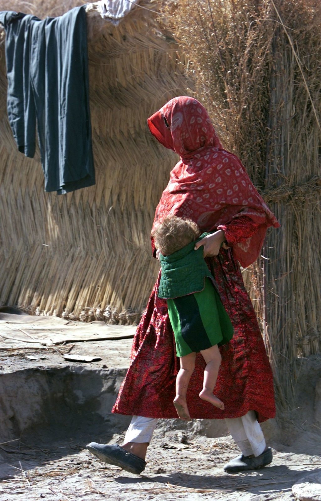 An Afghan woman carries her child at the Toza Lokay refugee camp on the Tajik-Afgan border, some 250 km south from Dushanbe | Photo: Dmitry Khrupov/ARCHIVE/EPA/ANSA