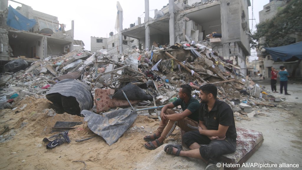 A Palestinian family sits by the rubble in Gaza's Rafah refugee camp following an Israeli strike, Oct. 9, 2023 | Photo: AP Photo/Hatem Ali