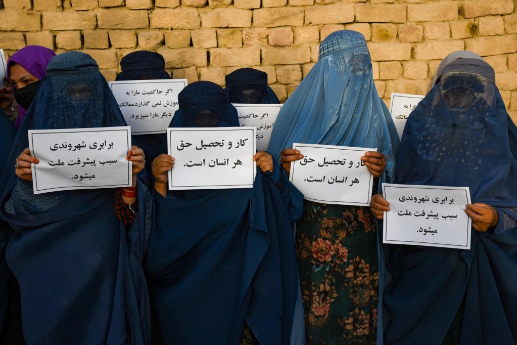 AFP - ATEF ARYAN | Afghan burqa-clad women hold placards as they protest for their right to education, in Mazar-i-Sharif on 12 August, 2023. 