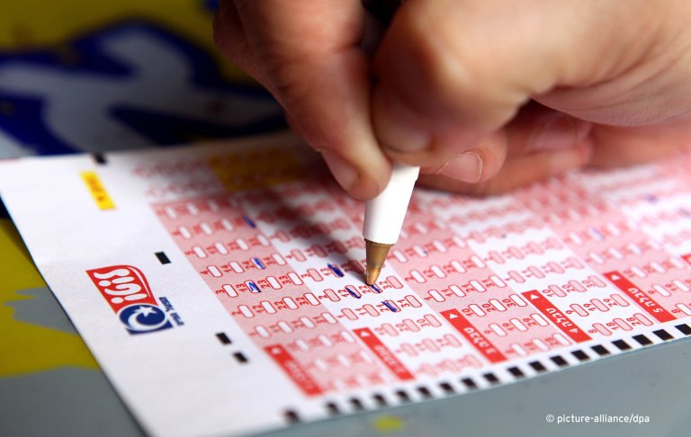 A person filling out a lottery ticket in Jerusalem | Photo: Picture-alliance/Abir Sultan