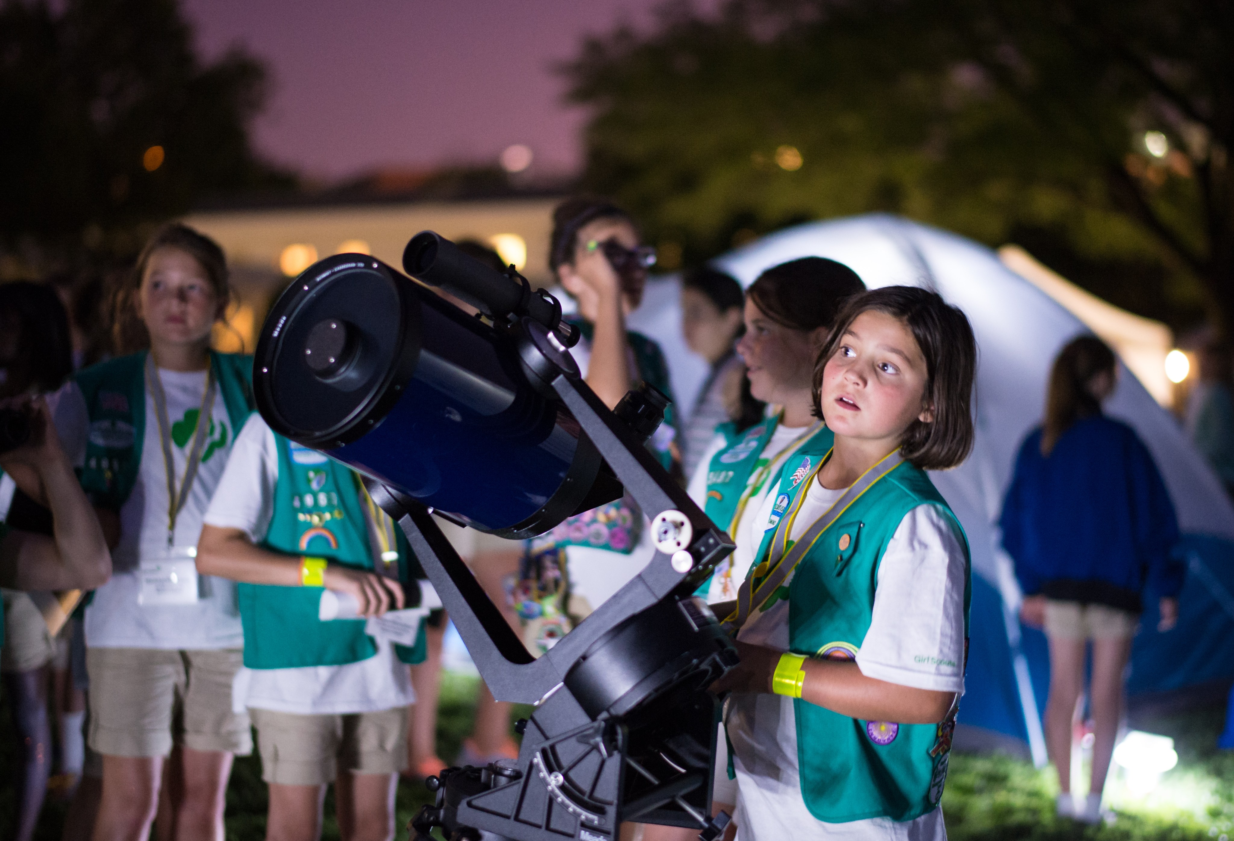 A crowd of Girl Scouts gathered around a telescope outside the White House.