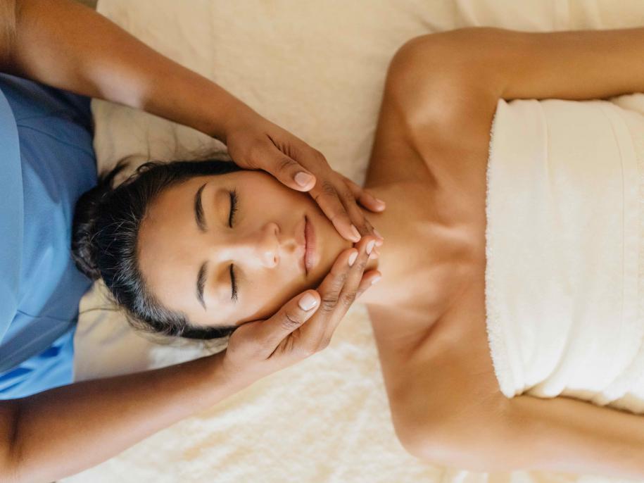 Woman relaxing on a bed at the sls baha mar spa getting a facial