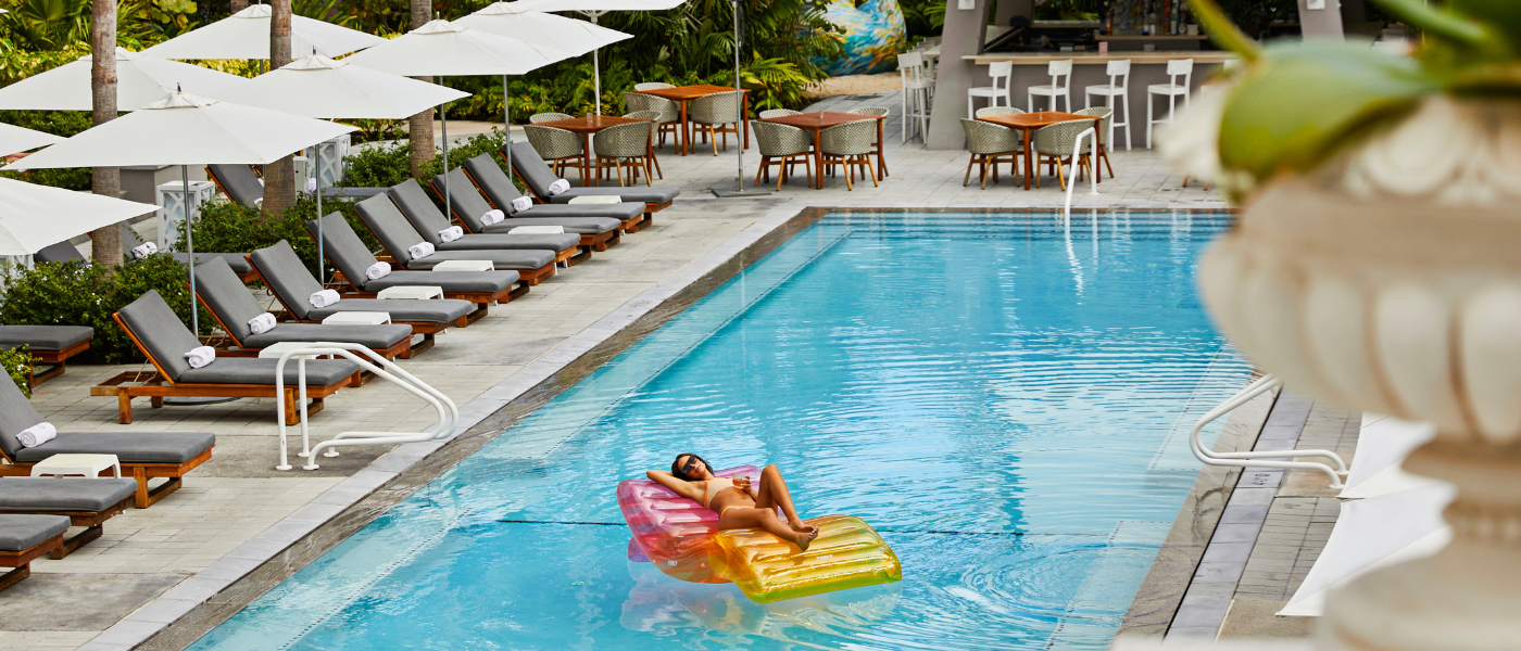 a woman lounging on a colorful floatie in a pristine pool