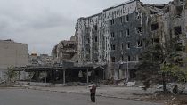 A woman walks in front of Druzhba hotel destroyed by Russian airstrikes in Pokrovsk, Monday, Nov. 11, 2024