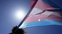 Una persona ondea la bandera trans