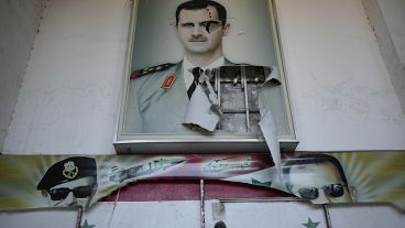 Um cartaz rasgado mostra o presidente sírio deposto Bashar Al-Assad em Damasco, Síria, (14 de dezembro de 2024)