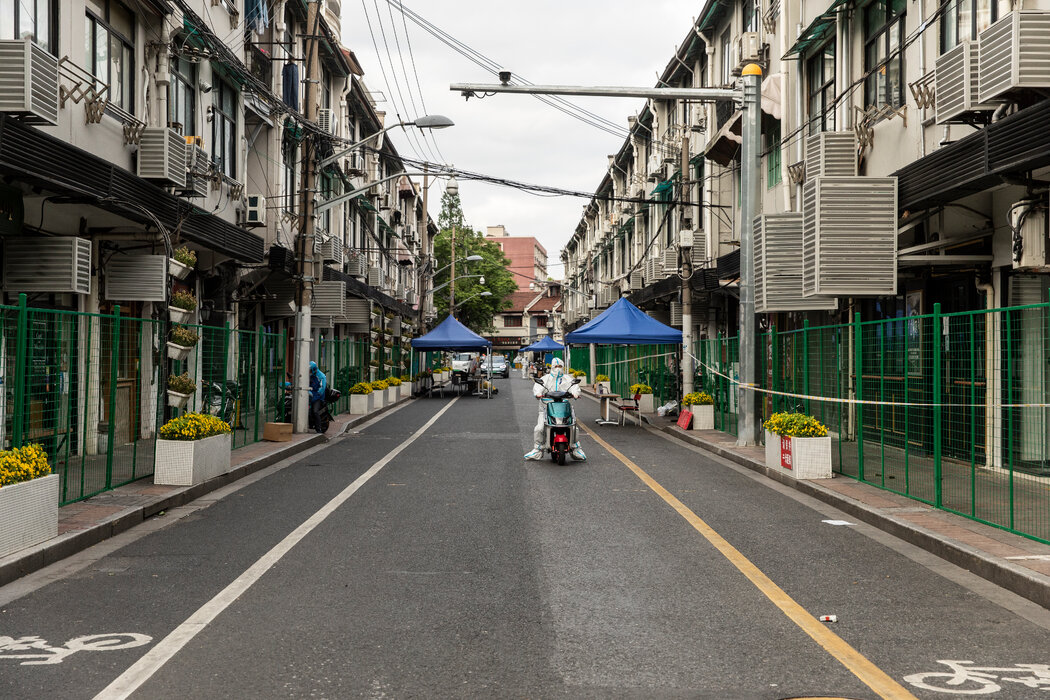 去年4月封城期间，上海一条被围栏封锁的街道。在那段时间里，许多民众无法看病拿药或购买食物。