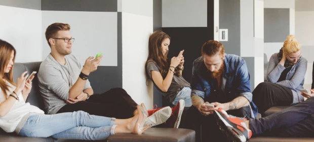 Junge Menschen in einem Raum mit Smartphones